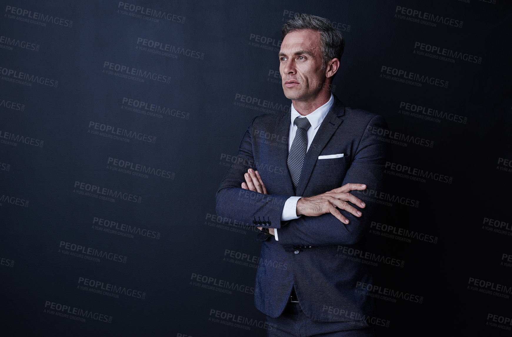 Buy stock photo Studio shot of a confident and mature businessman standing against a dark background