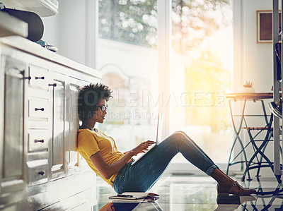 Buy stock photo Full length shot of an attractive young woman using her laptop while chilling at home