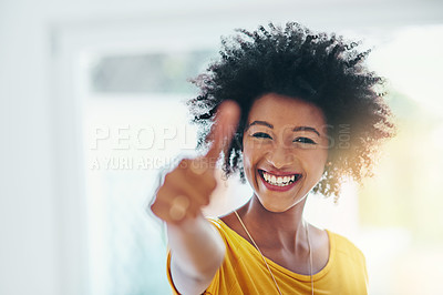 Buy stock photo Portrait of an attractive young woman giving you the thumbs up while chilling at home