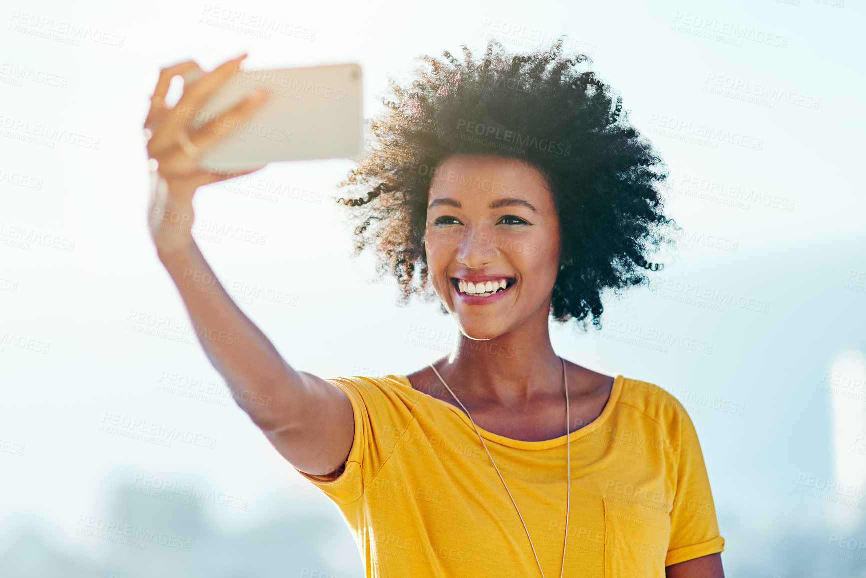 Buy stock photo Cropped shot of an attractive young woman taking selfies while standing outside