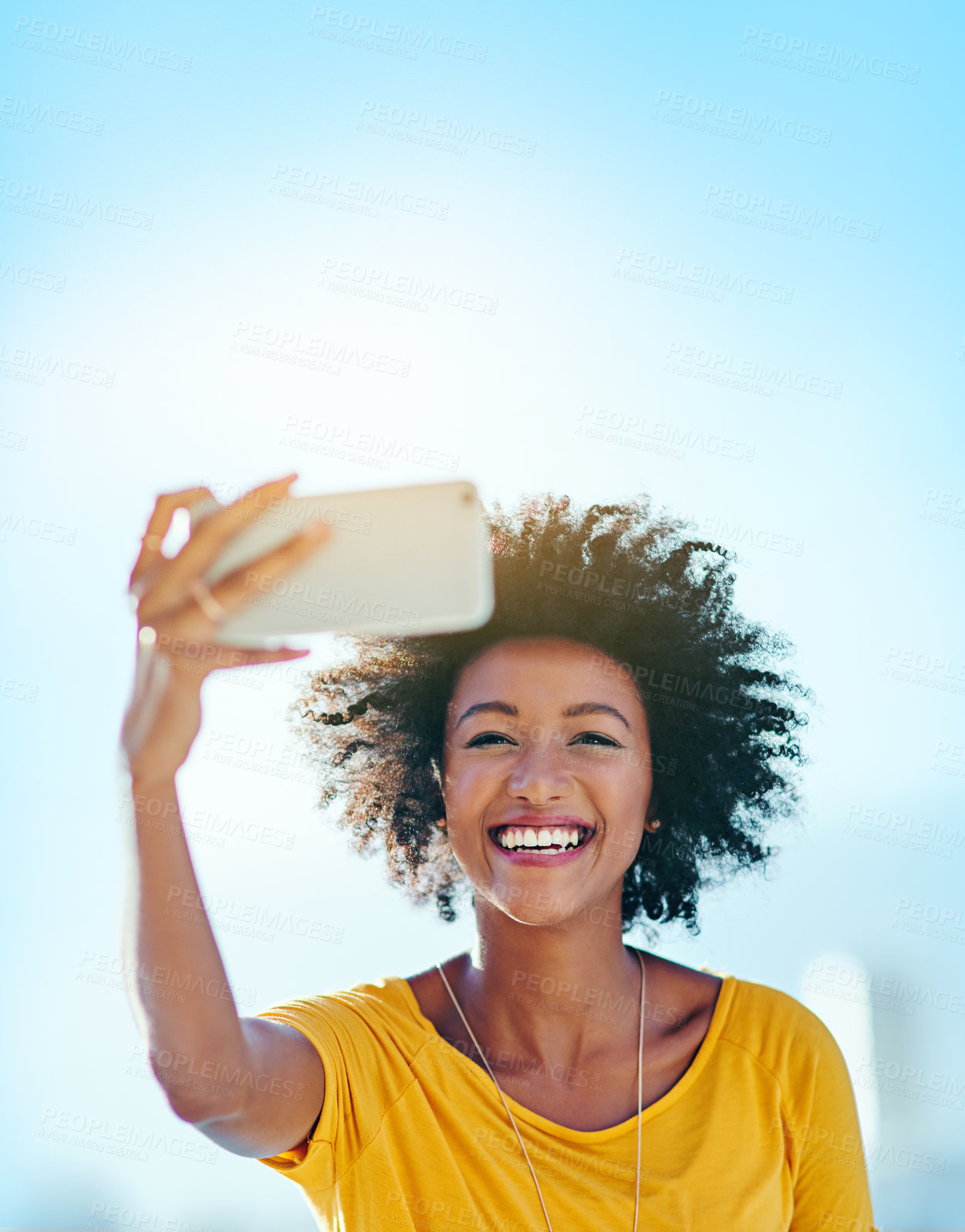 Buy stock photo Cropped shot of an attractive young woman taking selfies while standing outside