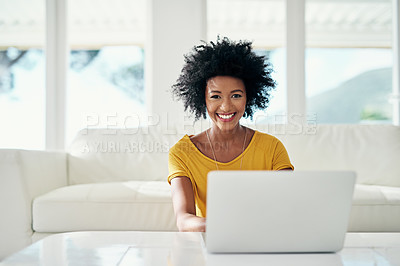 Buy stock photo Cropped portrait of an attractive young woman using her laptop while chilling at home
