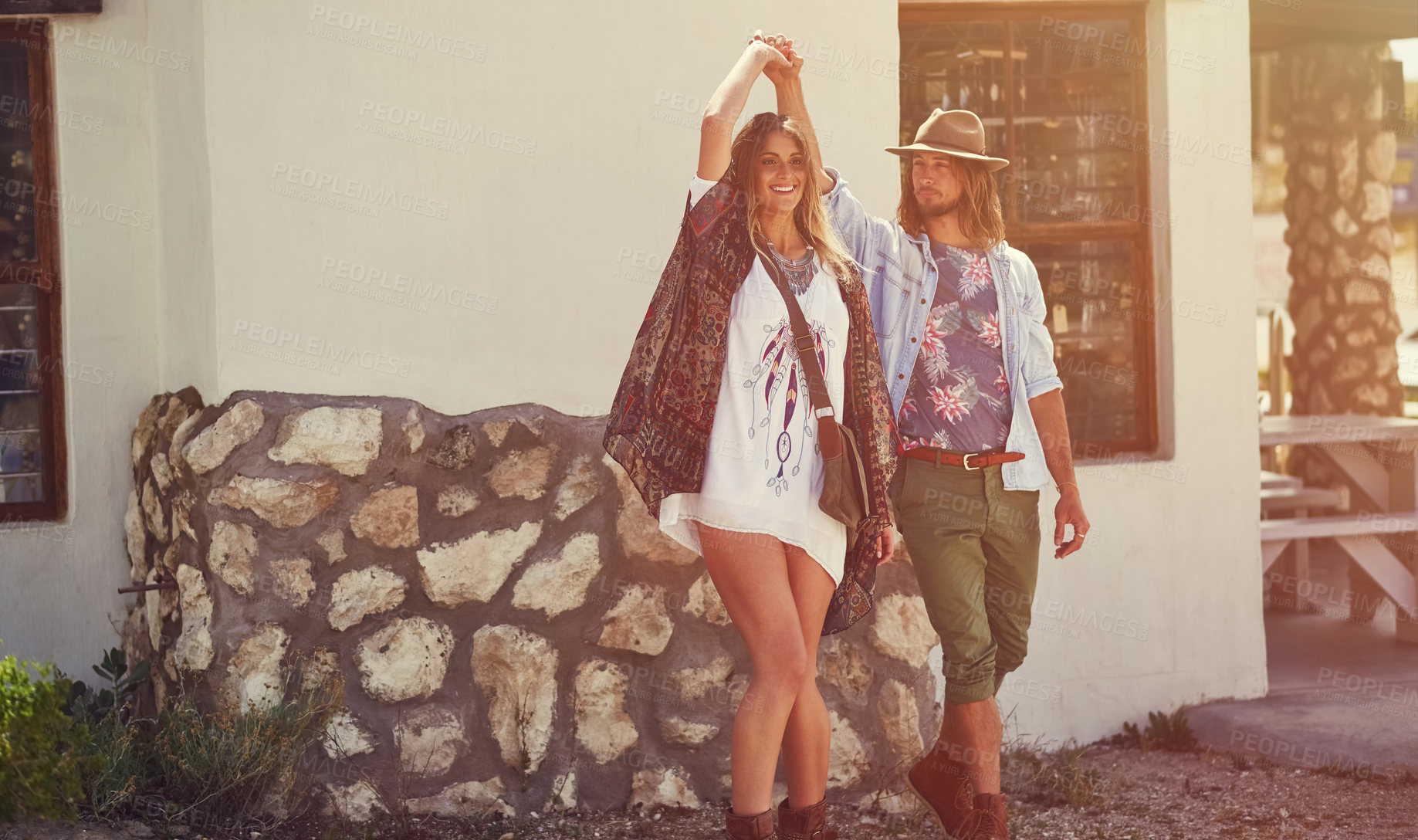 Buy stock photo Shot of an affectionate young couple dancing outside a roadside shop