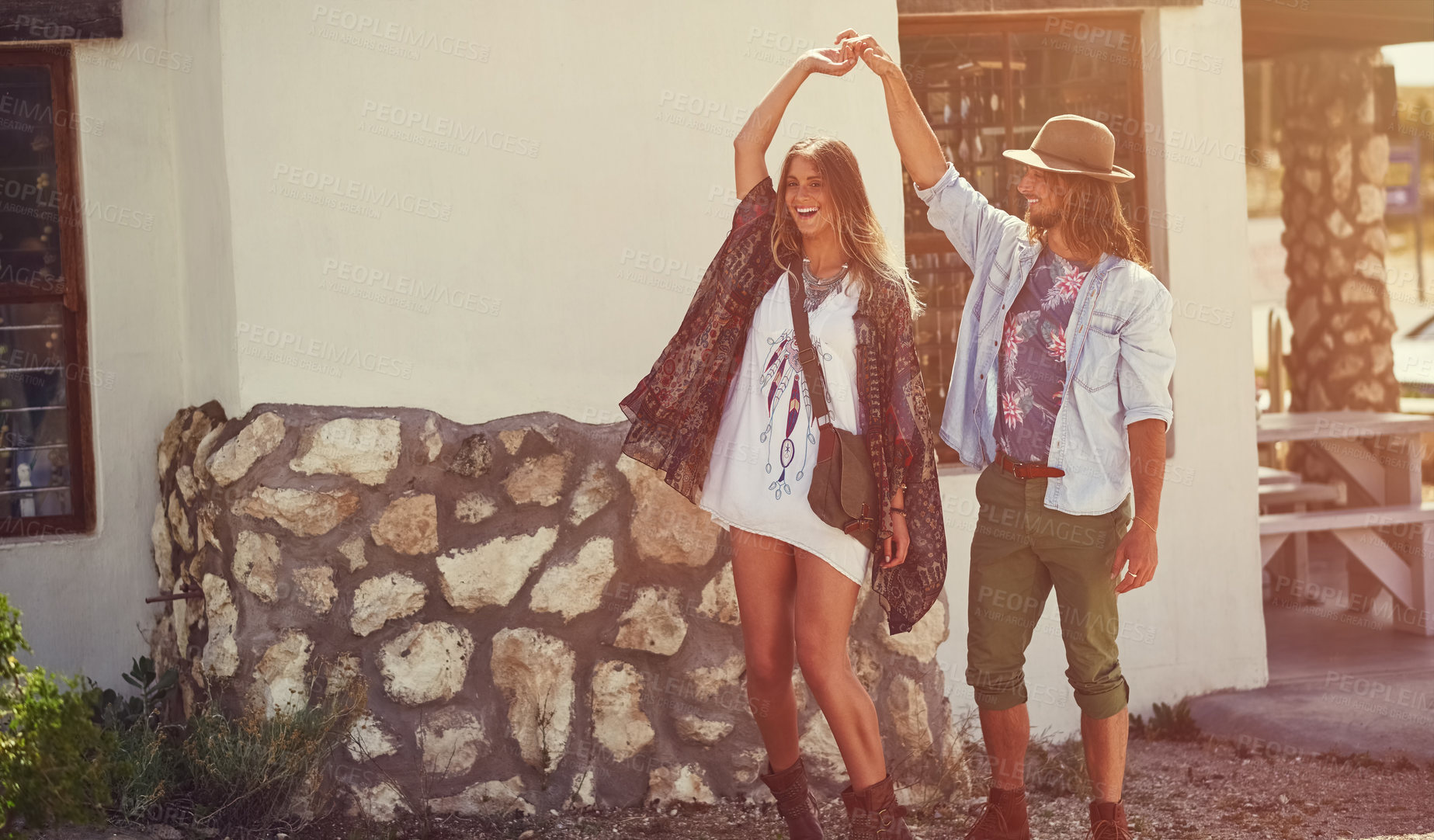 Buy stock photo Shot of an affectionate young couple dancing outside a roadside shop