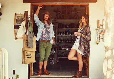Buy stock photo Shot of an affectionate young couple posing outside a roadside shop