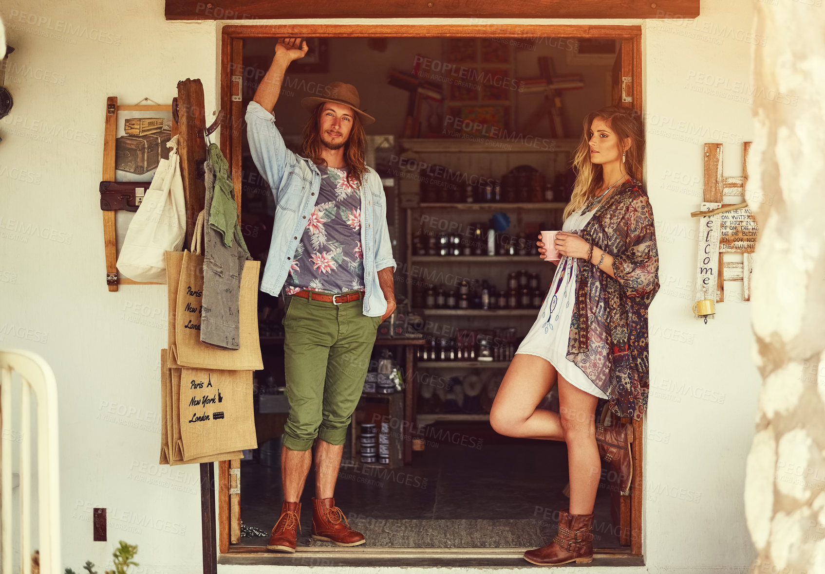 Buy stock photo Shot of an affectionate young couple posing outside a roadside shop