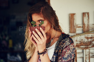 Buy stock photo Portrait of a free spirited young woman admiring a pot plant in her hands