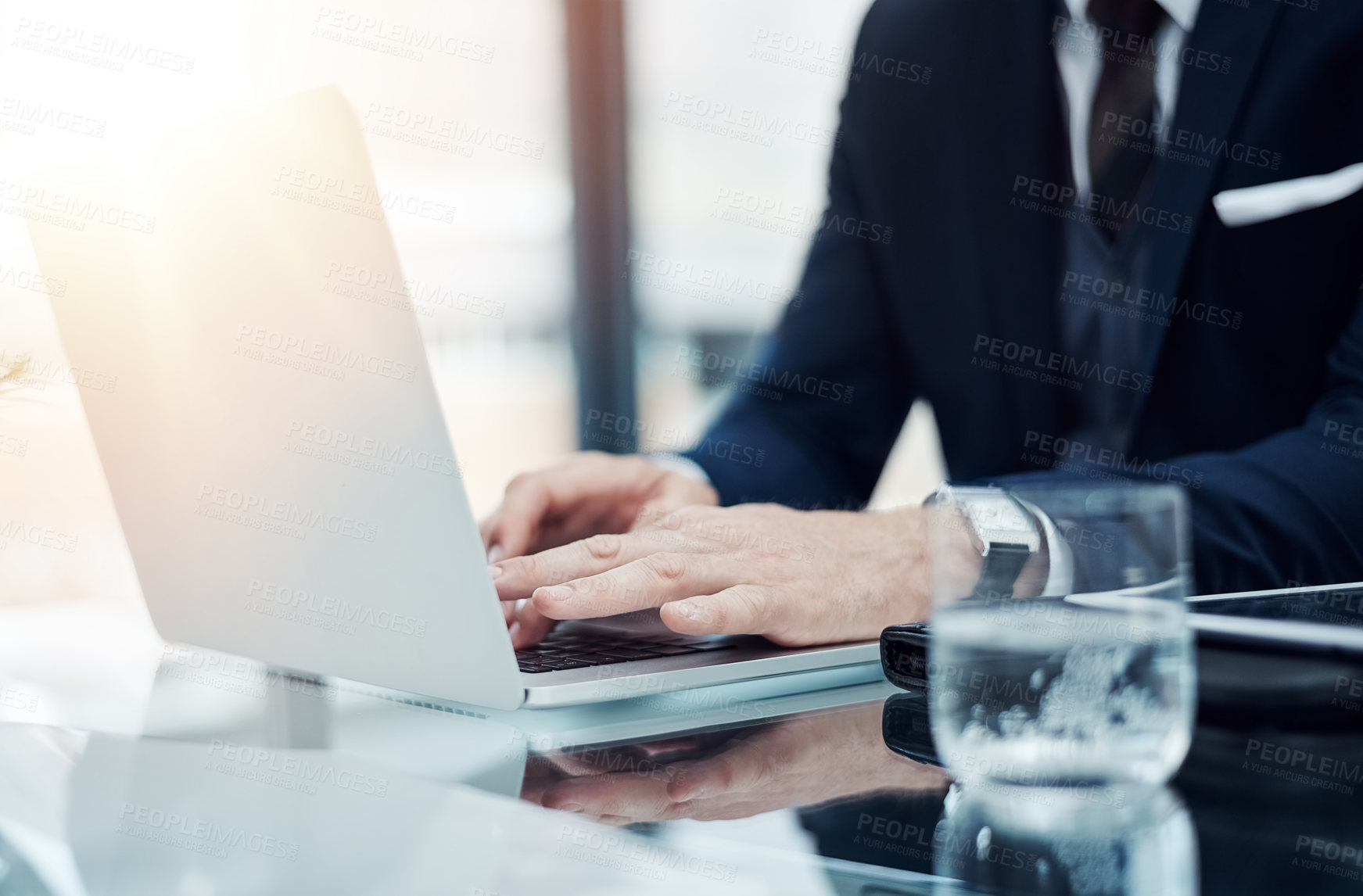 Buy stock photo Shot of an unidentifiable businessman working on a laptop in an office