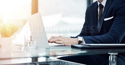 Buy stock photo Shot of an unidentifiable businessman working on a laptop in an office