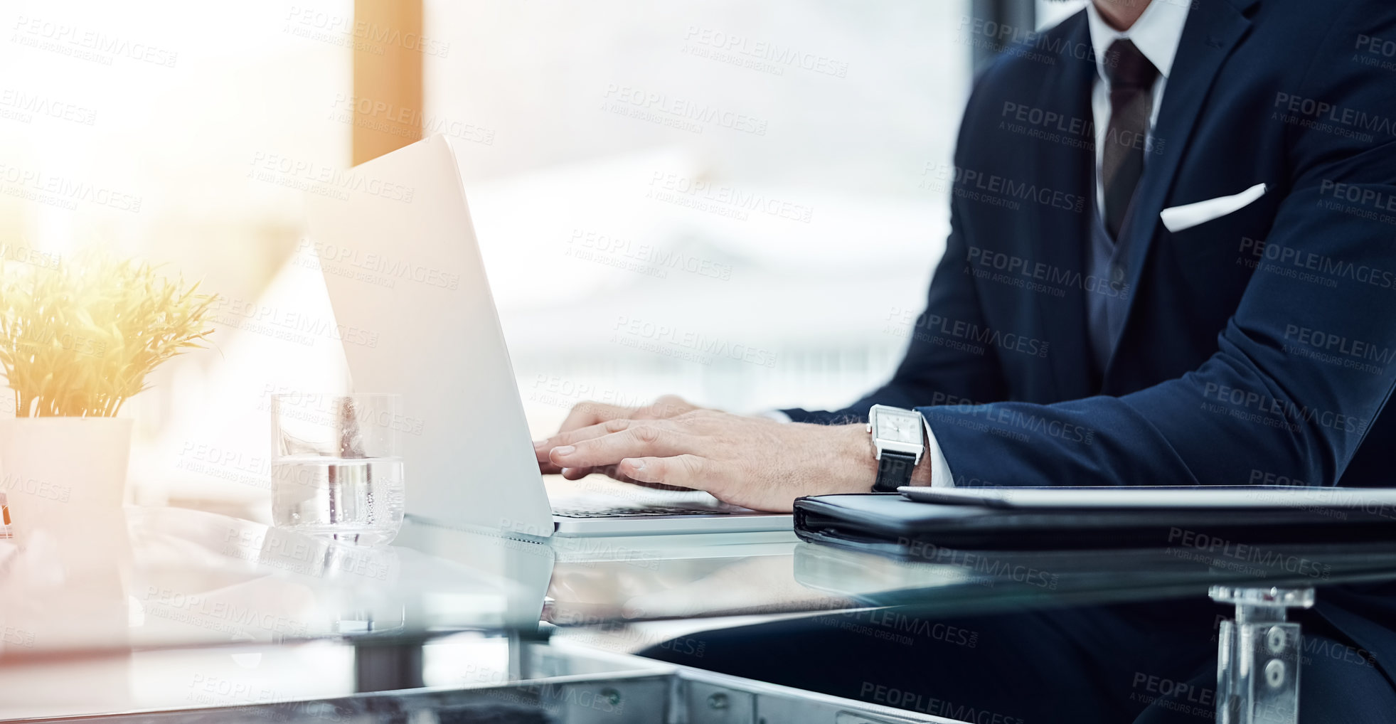 Buy stock photo Shot of an unidentifiable businessman working on a laptop in an office