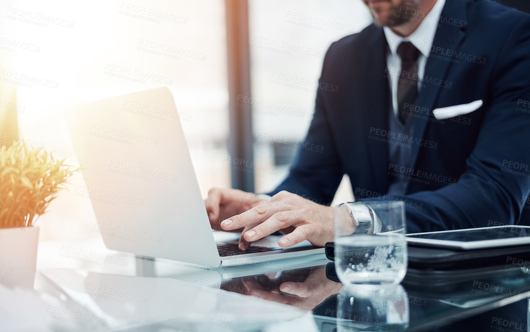 Buy stock photo Shot of an unidentifiable businessman working on a laptop in an office