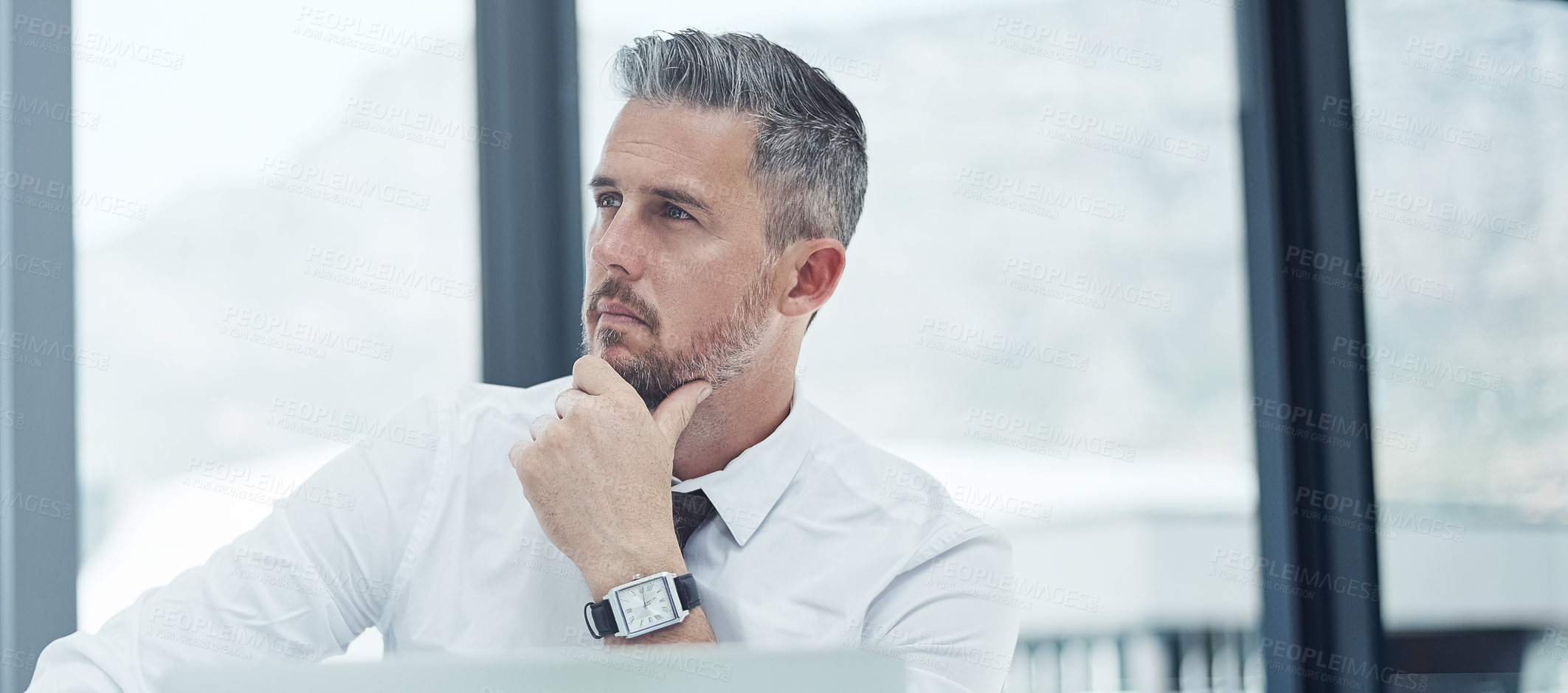 Buy stock photo Shot of a corporate businessman looking thoughtful while working in an office