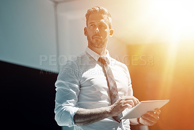 Buy stock photo Shot of a corporate businessman using a digital tablet in an office