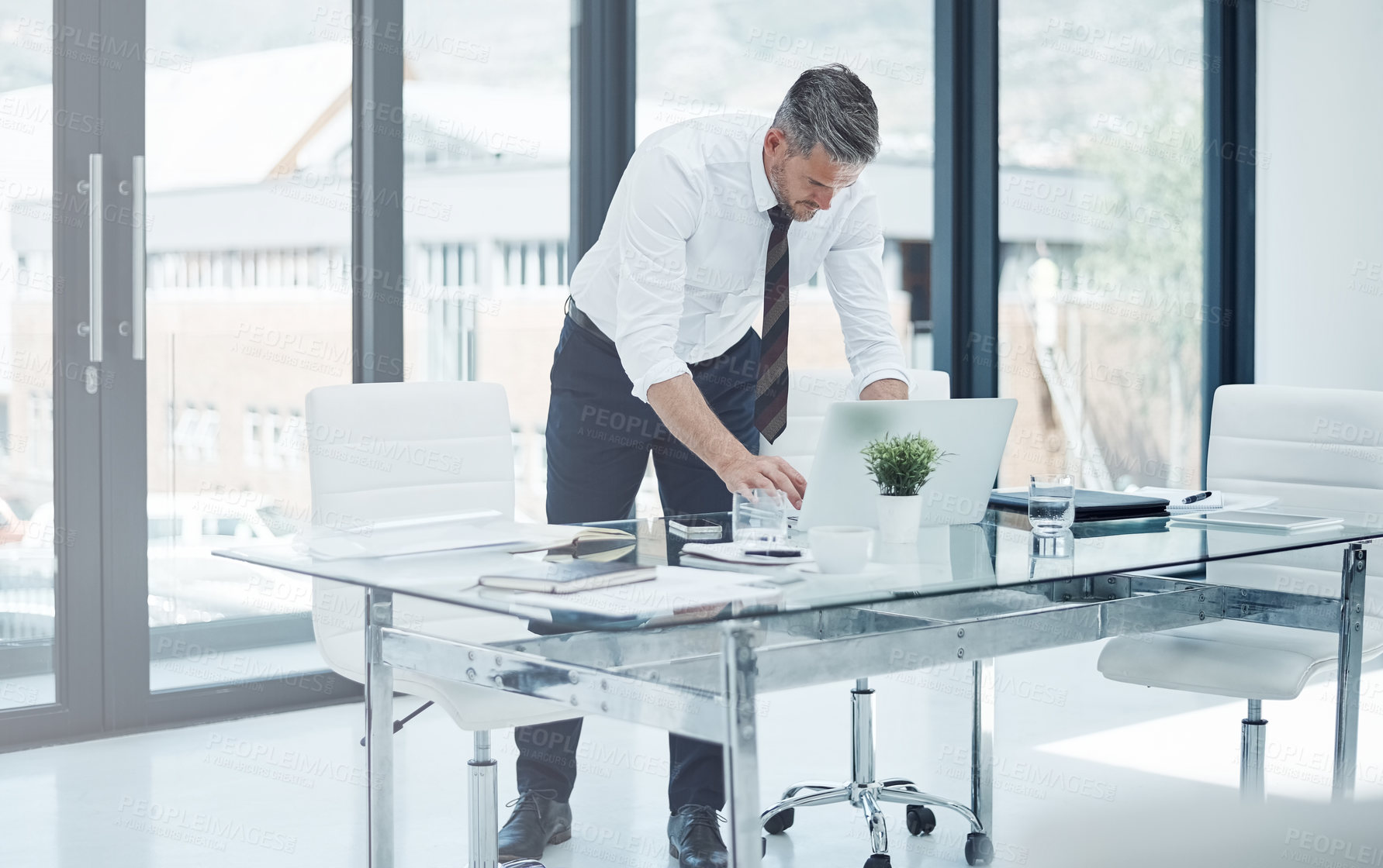 Buy stock photo Shot of a corporate businessman working in an office