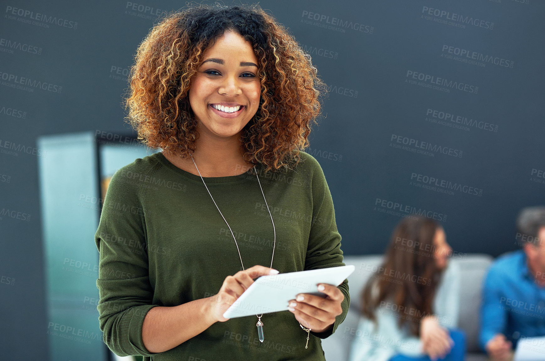 Buy stock photo Portrait of a young businesswoman using a digital tablet with her team in the background
