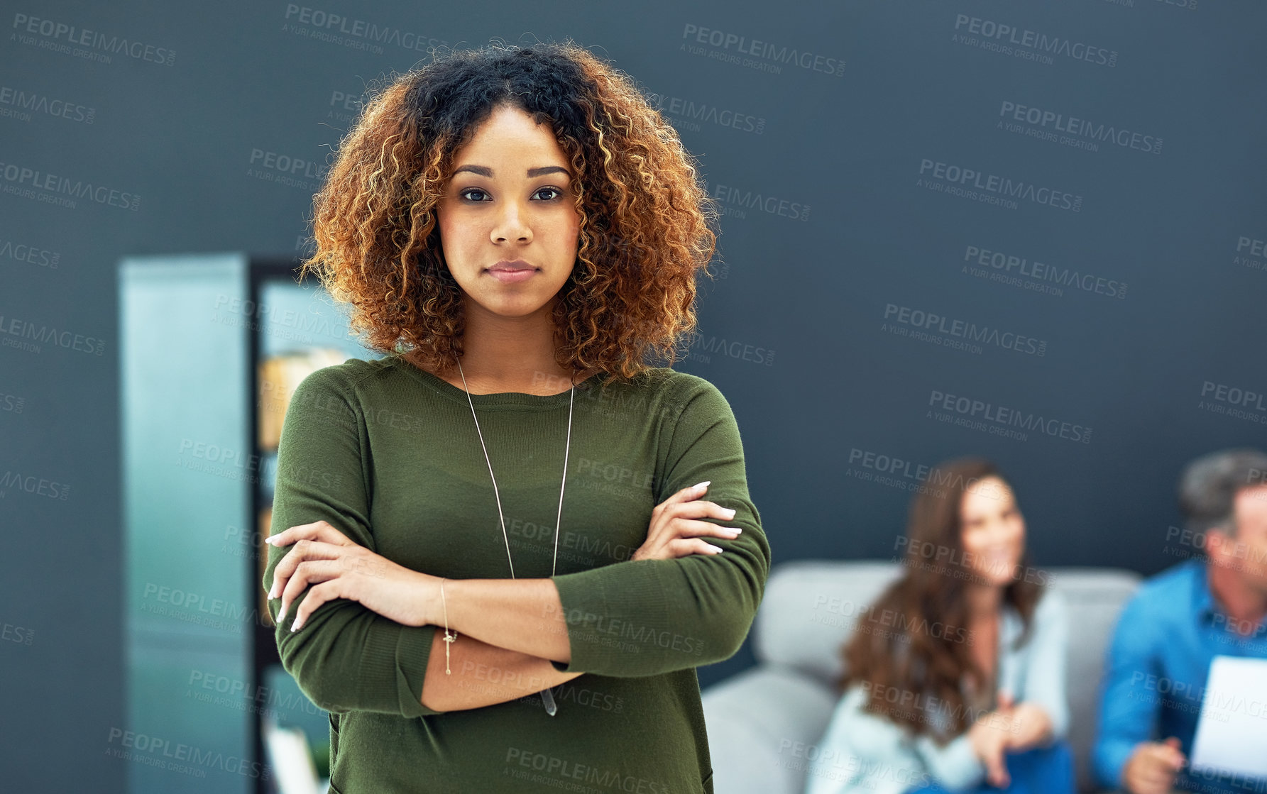 Buy stock photo Portrait of a confident young businesswoman with her team blurred in the background