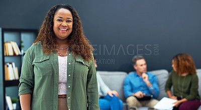 Buy stock photo Portrait of a confident young businesswoman with her team blurred in the background