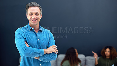 Buy stock photo Portrait of a confident mature businessman with his team blurred in the background