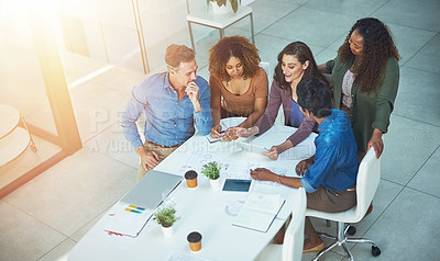 Buy stock photo Shot of a group of designers gathering around a woman using a tablet in a meeting