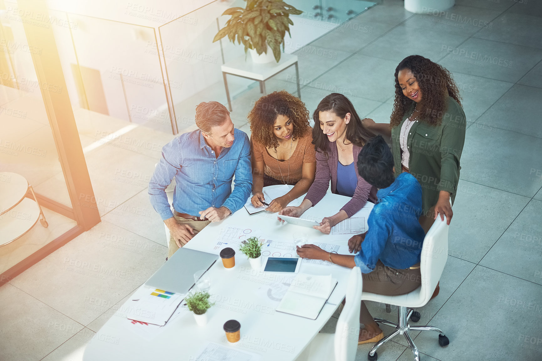 Buy stock photo Shot of a creative team using a digital tablet together during a meeting at work