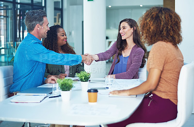 Buy stock photo Shot of two designers shaking hands during a meeting