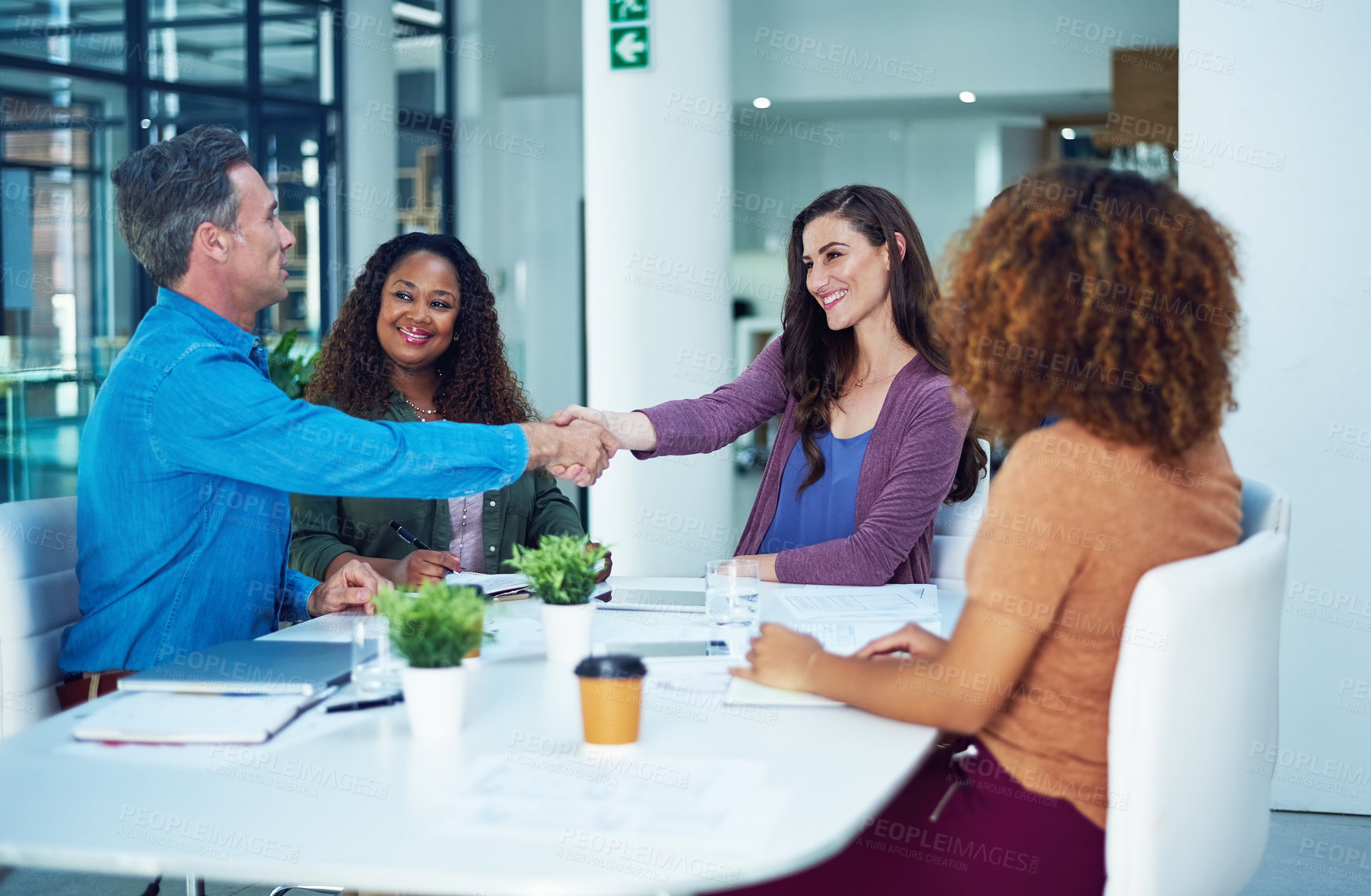 Buy stock photo Shot of two designers shaking hands during a meeting