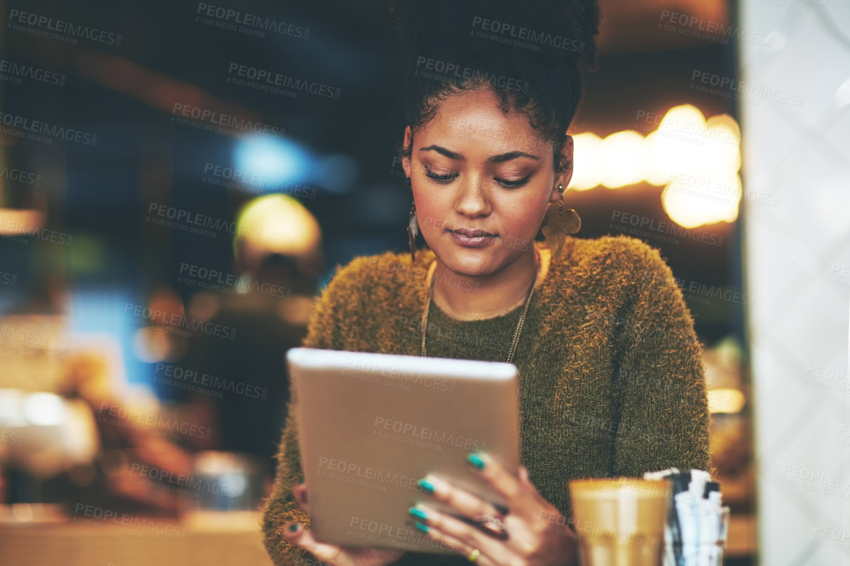 Buy stock photo Shot of a young woman using a digital tablet at a coffee shop