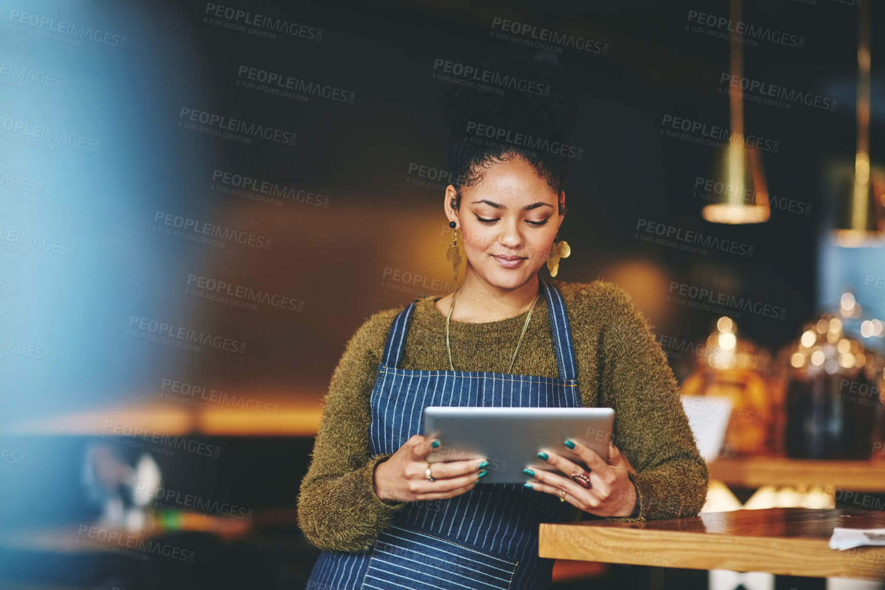 Buy stock photo Shot of a young woman using a  digital tablet while working at a coffee shop