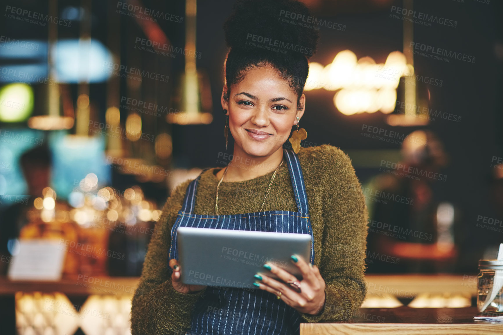 Buy stock photo Shot of a young woman using a  digital tablet while working at a coffee shop