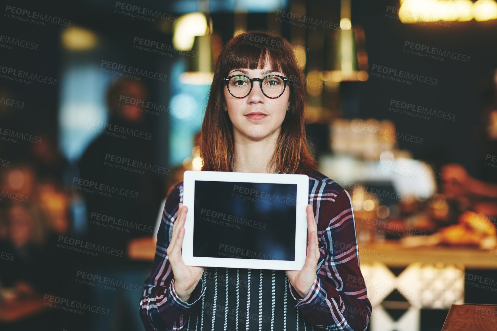 Buy stock photo Shot of a young woman holding a digital tablet with a blank screen in a coffee shop