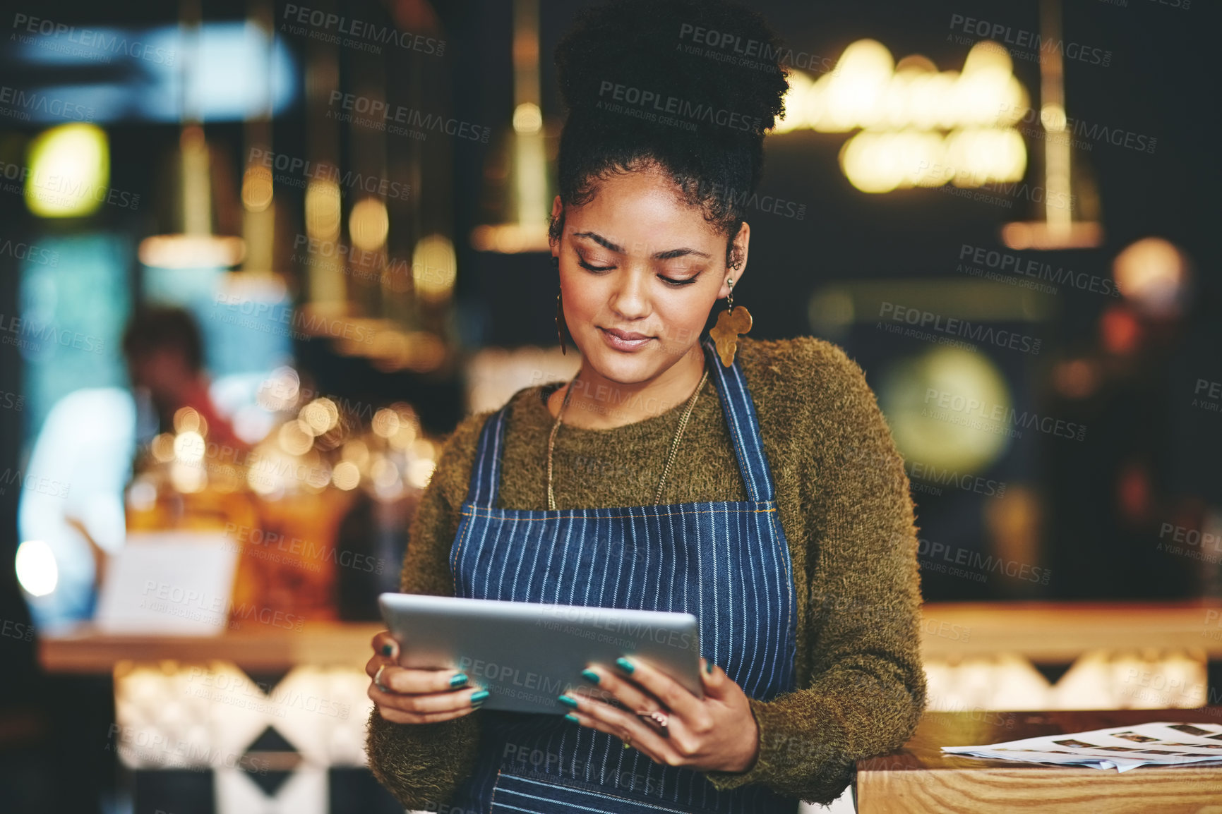 Buy stock photo Shot of a young woman using a  digital tablet while working at a coffee shop