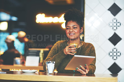 Buy stock photo Shot of a young woman using a digital tablet at a coffee shop