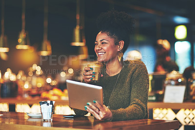 Buy stock photo Shot of a young woman using a digital tablet at a coffee shop