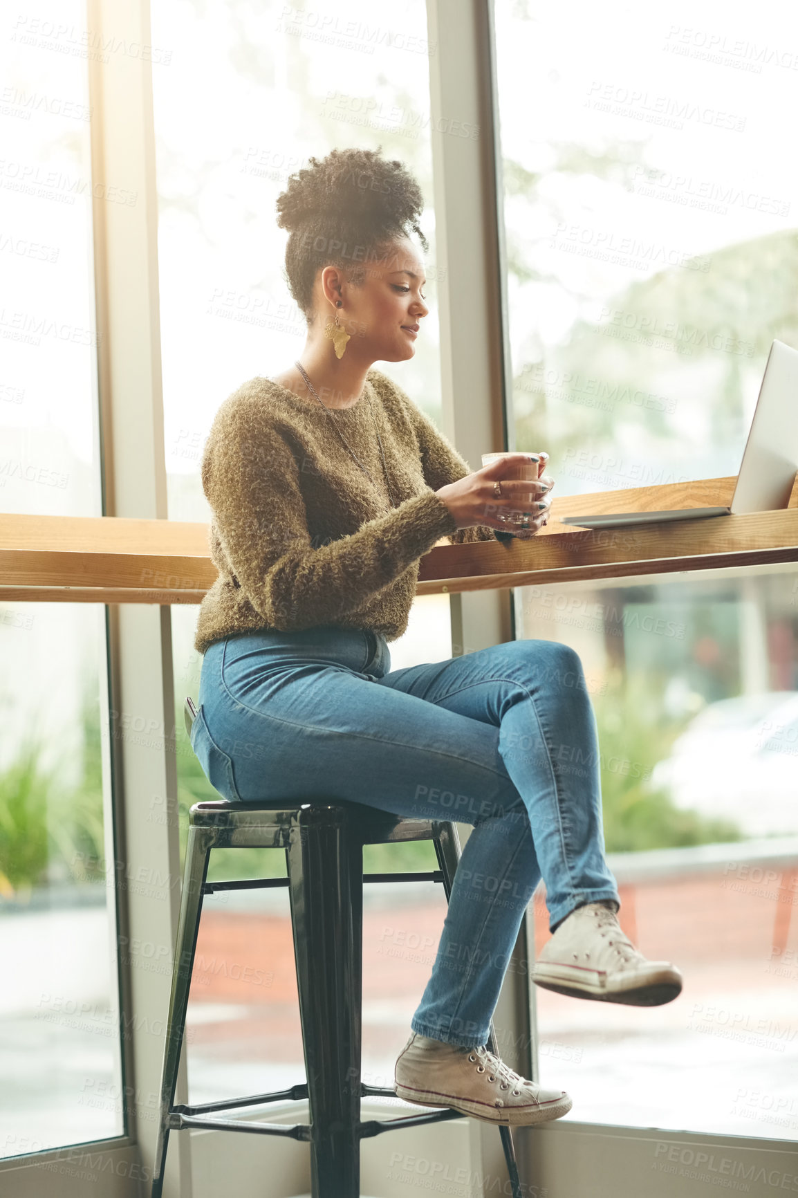 Buy stock photo Shot of an attractive young woman using her laptop in a cafe