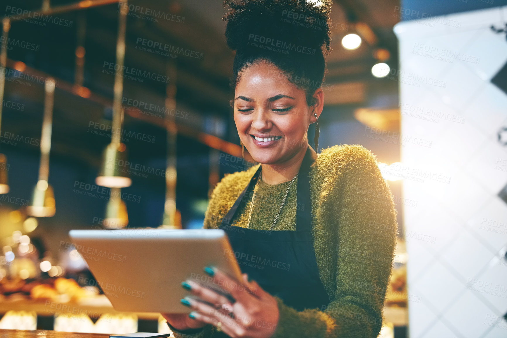 Buy stock photo Shot of a young woman using a  digital tablet while working at a coffee shop