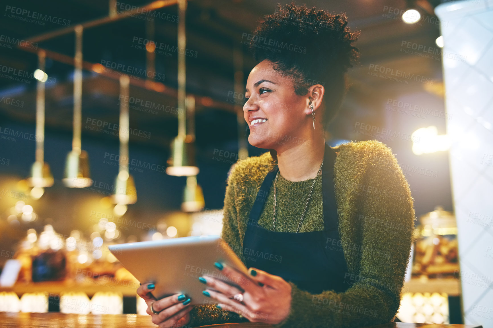 Buy stock photo Shot of a young woman using a  digital tablet while working at a coffee shop