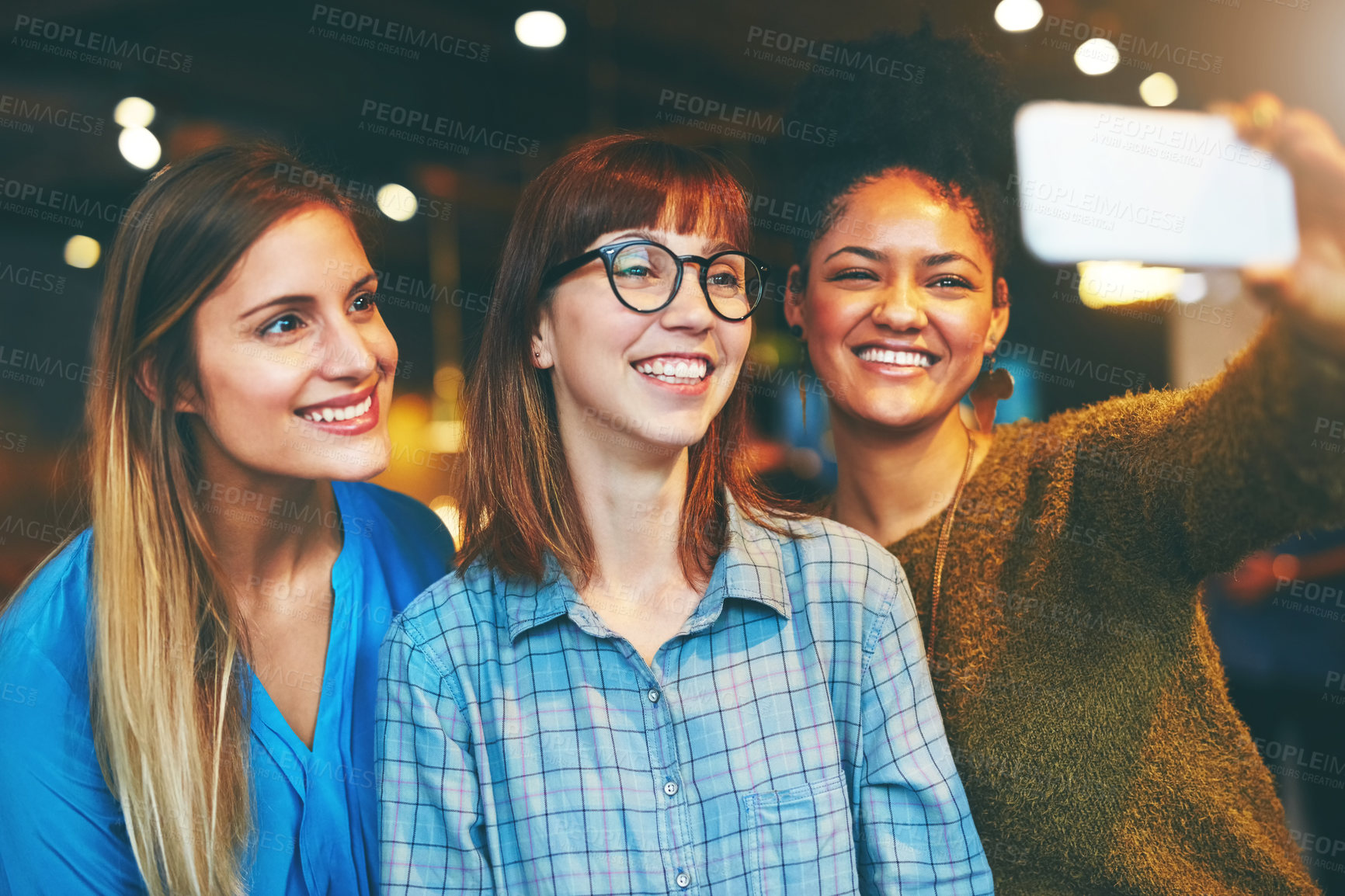 Buy stock photo Shot of three young friends taking a selfie together in a cafe