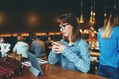 Buy stock photo Shot of an attractive young woman using a digital tablet in a cafe