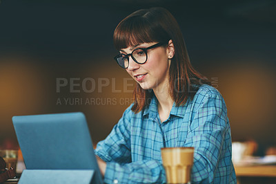 Buy stock photo Shot of an attractive young woman using a digital tablet in a cafe