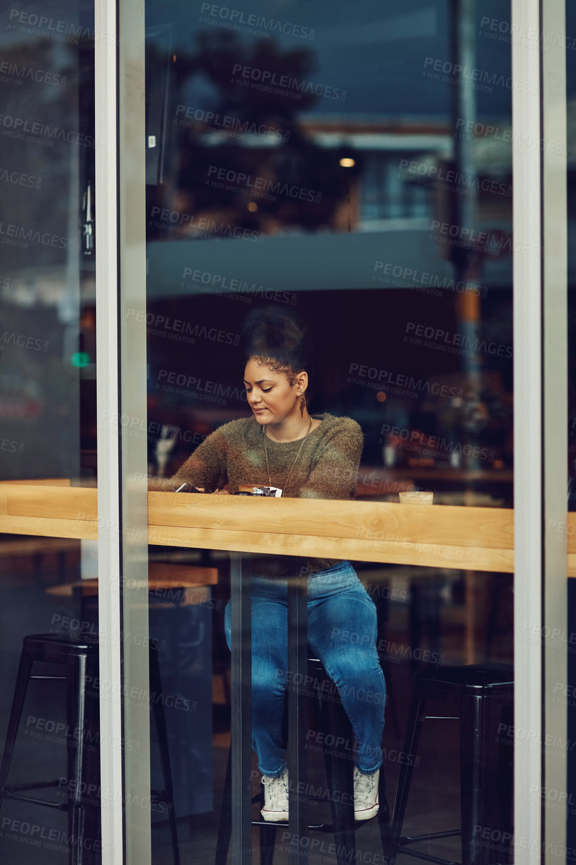 Buy stock photo Shot of an attractive young woman sitting in a cafe