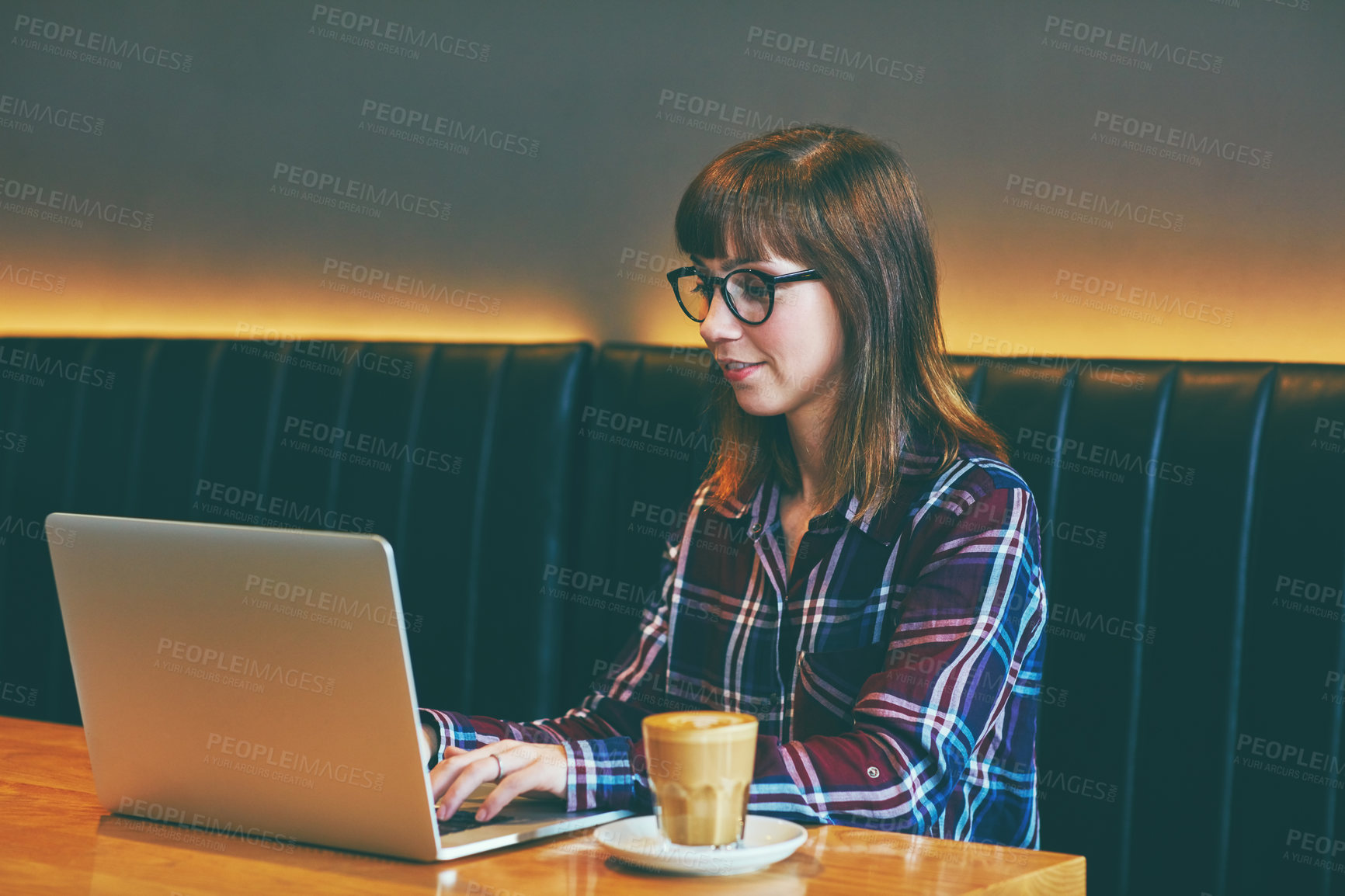 Buy stock photo Cropped shot of an attractive young woman using her laptop in a cafe