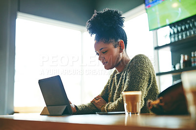 Buy stock photo Cropped shot of an attractive young woman using a digital tablet in a cafe