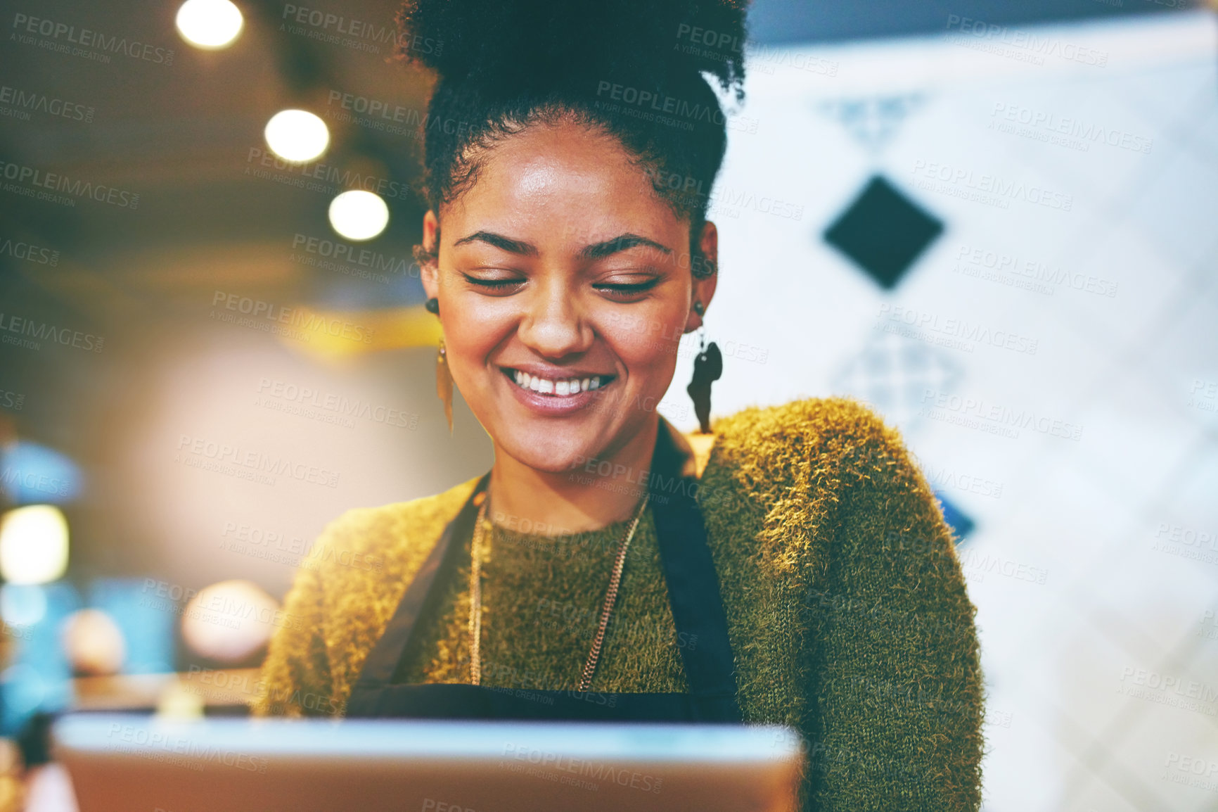 Buy stock photo Shot of a young business owner using a digital tablet in her cafe