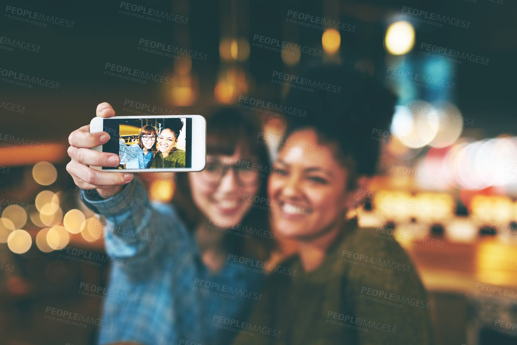 Buy stock photo Shot of two young friends taking a selfie together in a cafe