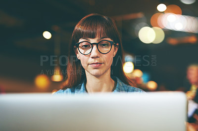 Buy stock photo Shot of an attractive young woman using her laptop in a cafe
