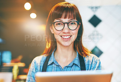Buy stock photo Portrait of a young business owner using a digital tablet in her cafe