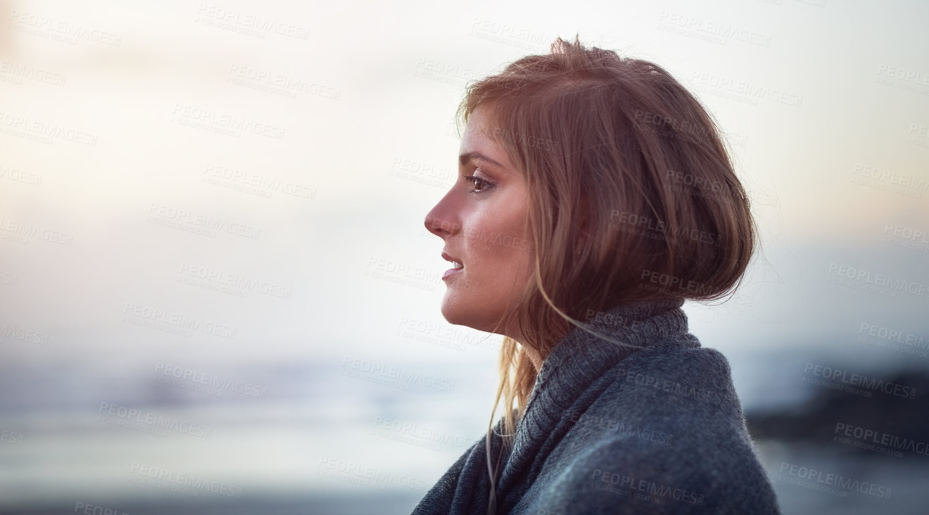 Buy stock photo Shot of an attractive young woman wrapped in a blanket on the beach