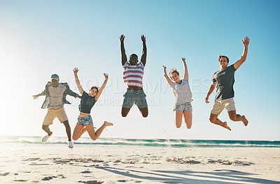 Buy stock photo Shot of a group of young friends jumping enthusiastically in the air at the beach