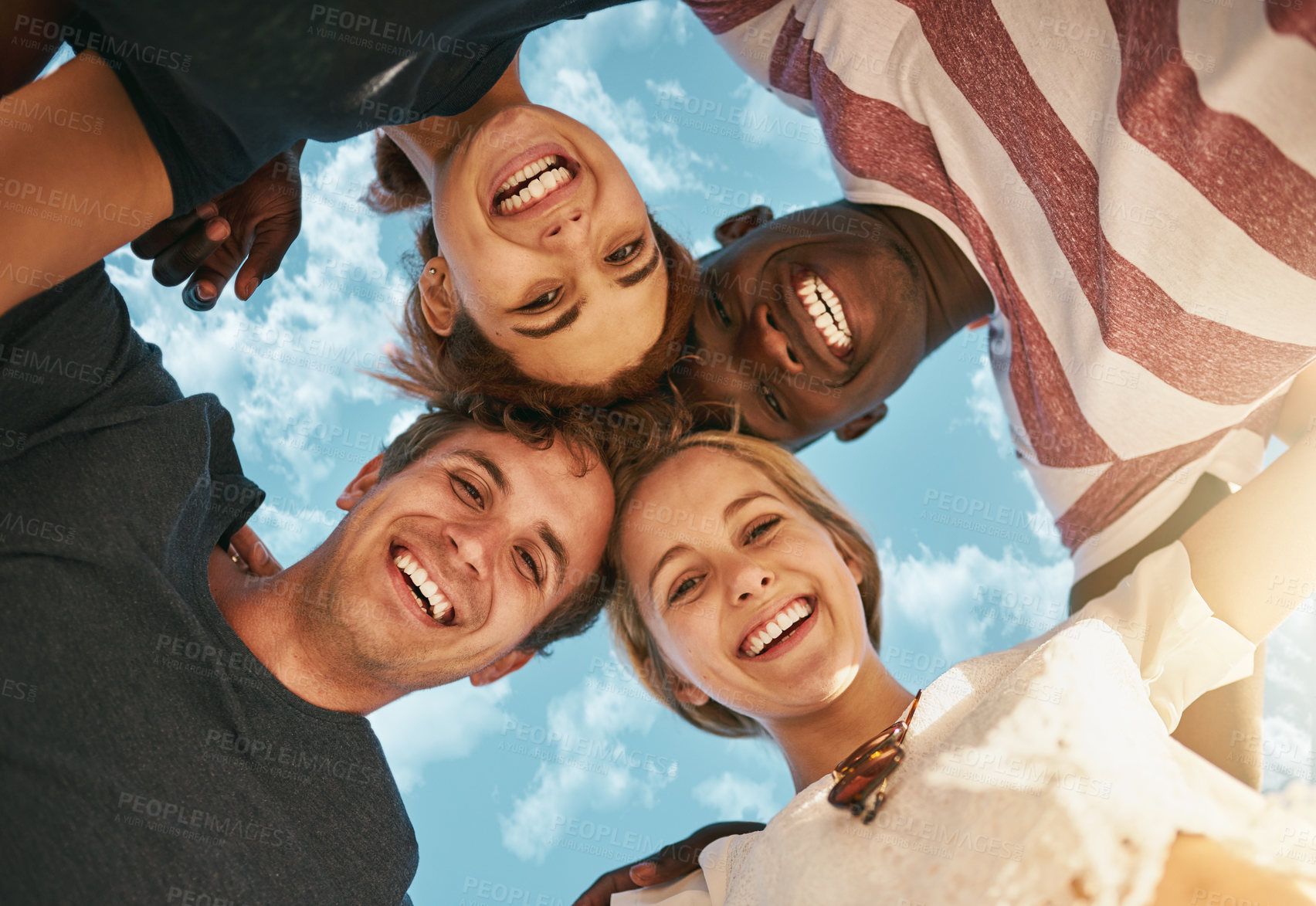 Buy stock photo Low angle, portrait and group of happy friends together outdoor for bonding, solidarity and community. Face, below and team of people huddle for collaboration, support and smile for diversity on sky