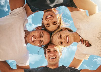 Buy stock photo Low angle shot of a group of young friends huddled together in solidarity